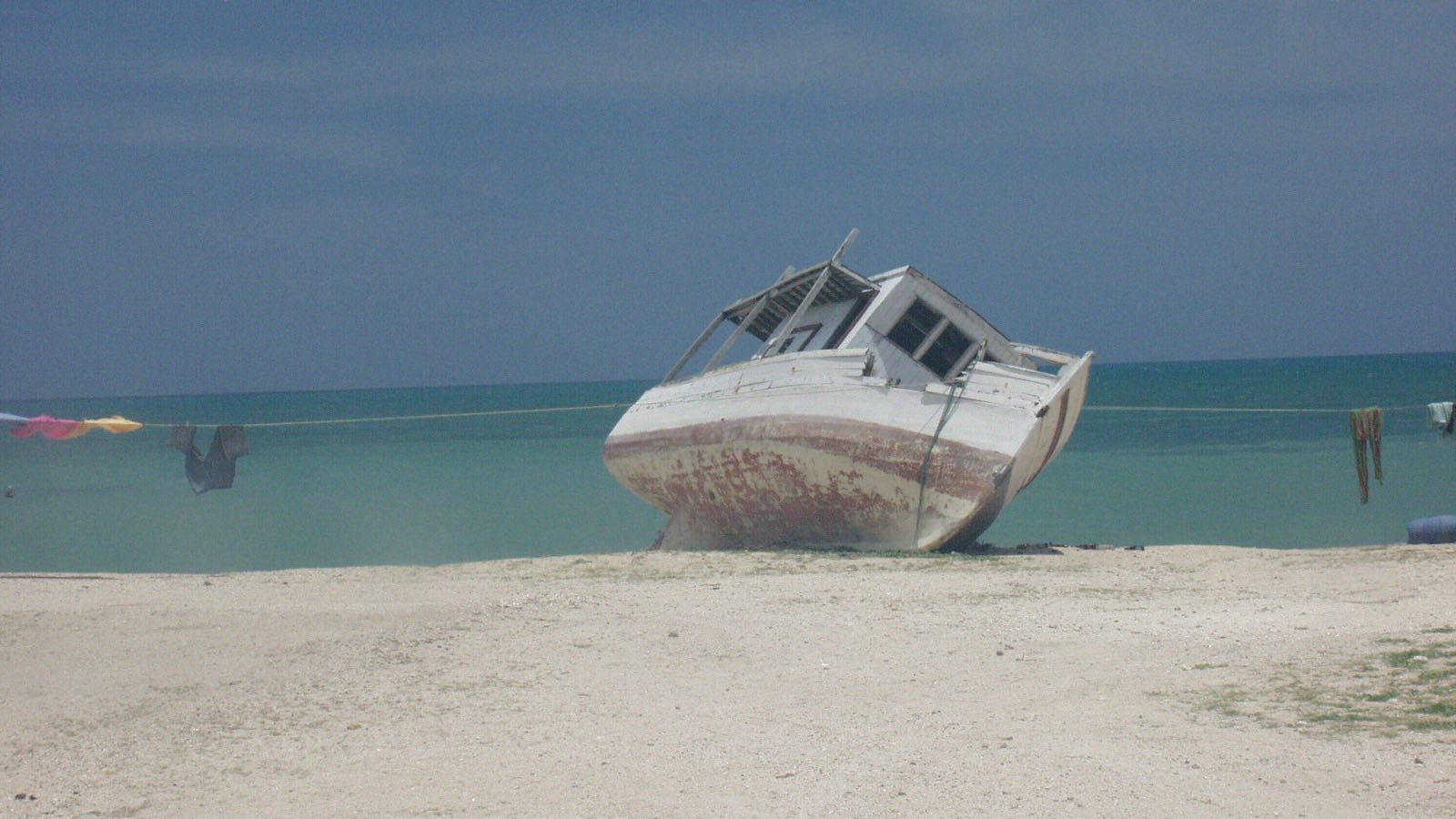 Barco varado en la arena y ropa tendida, Cabo de la Vela, La Guajira, Colombia